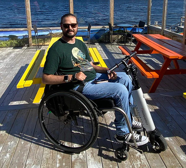 Active man utilizing his Cheelcare Companion while riding on a dock next to a seaside.