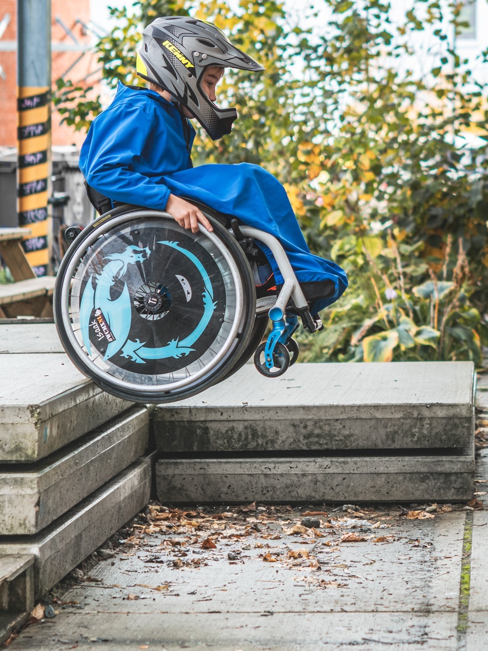 Image of a boy using the Kinetic Balance Wheelchair Blanker - Soft, fleece-lined blanket specifically designed for wheelchairs, offering warmth and comfort to users during colder weather.