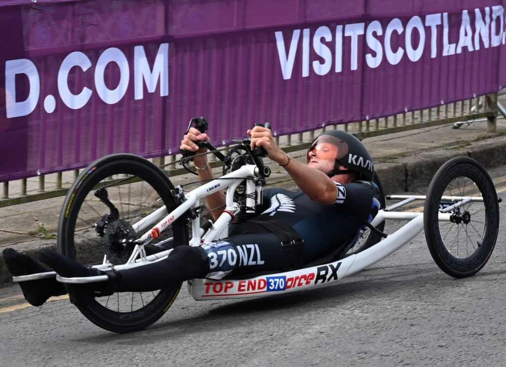 Image of an athletic man racing in his C7 Concepts, Tri-Spoke 20in Tubular Front Wheel.