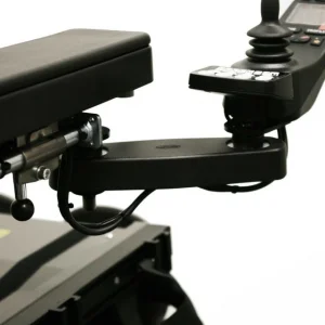 Side view of the Retractable Joystick Mount on wheelchair. A sleek, metal joystick mount attached to a wheelchair armrest. The joystick can be easily swung outwards or retracted sideways for improved accessibility.
