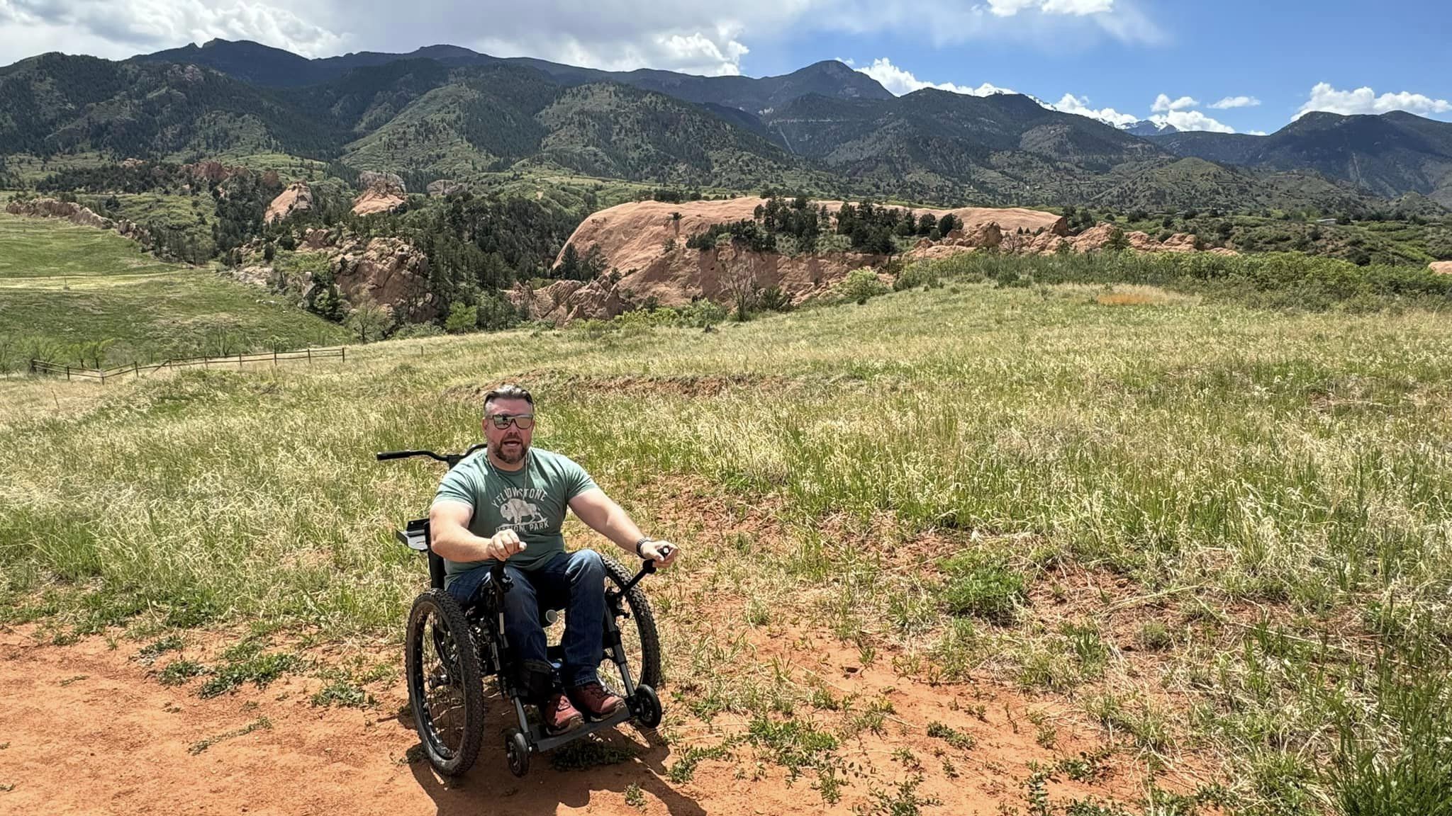 Image of a man in nature enjoying his Sirocco 2.0 Adventurer Power Assist - Compact, maneuverable wheelchair designed for outdoor adventures.